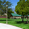 A public park with paths, trees, grass, and picnic shelters.