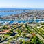Wide angle view from above of a coastal neighborhood with a boat basin and many boats docked or anchored