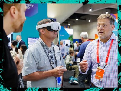 Attendee wearing a VR headset interacts with an Esri expert in the Expo hall.