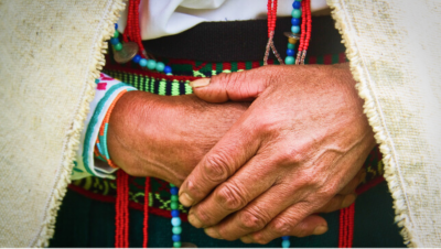 Tribal person with their hands folded 
