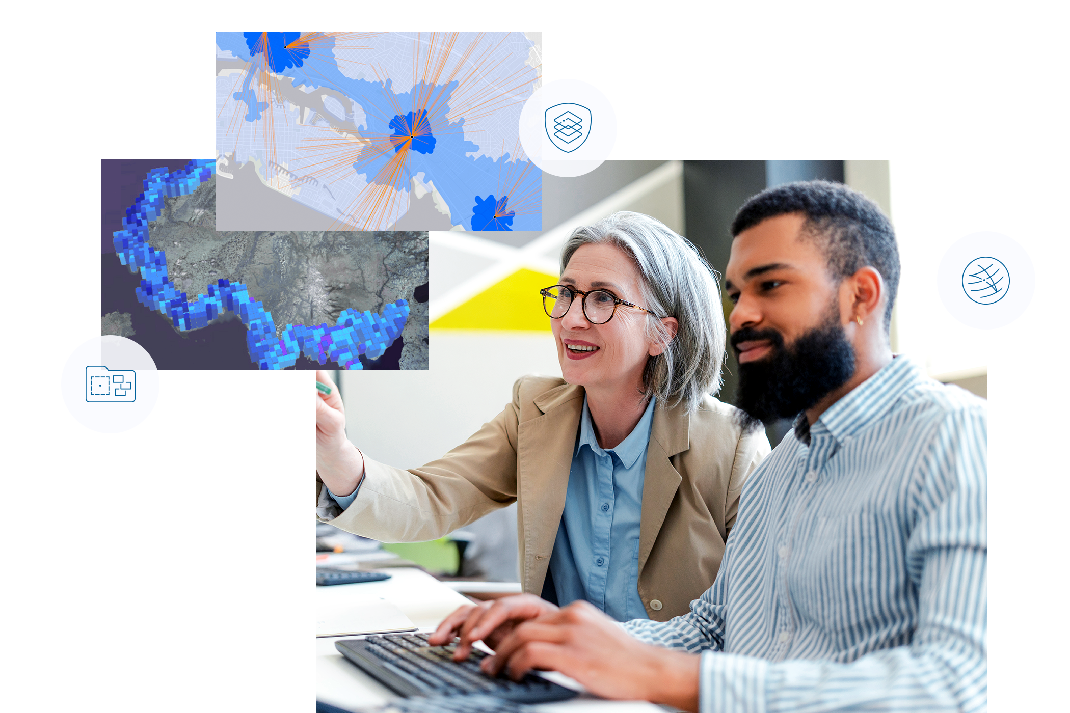 Two colleagues collaborate on a computer, analyzing geographic data visualizations displayed on the screen.