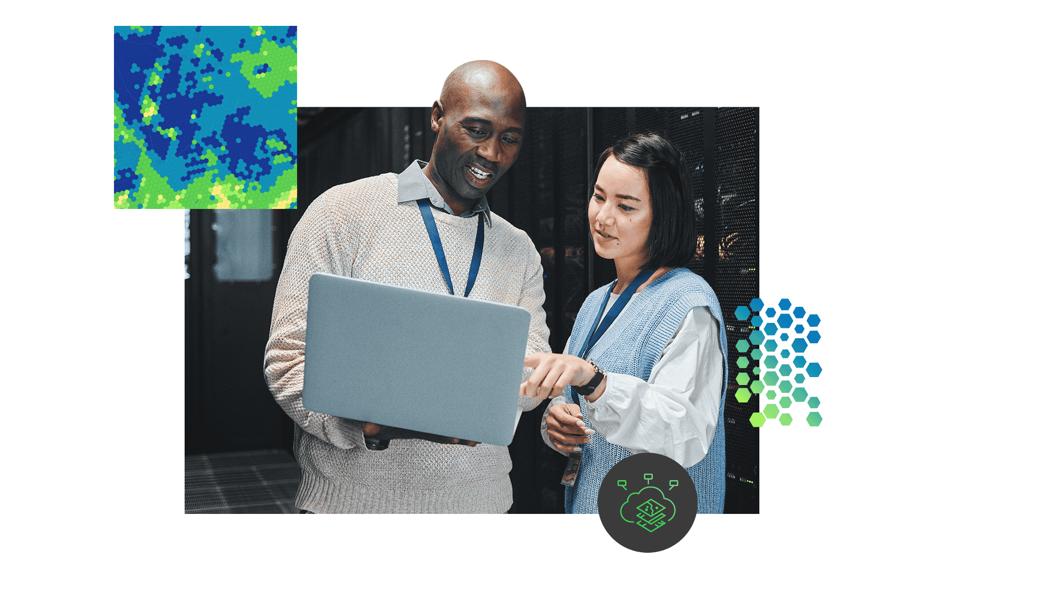 Two employees wearing badges, standing in a server room and looking at a laptop